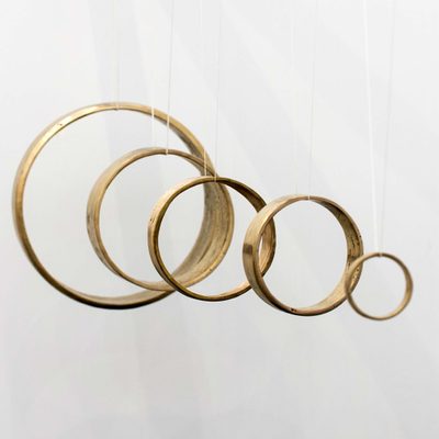 Five metal rings, suspended on wires so that they can be rung like a bell. The rings are hung in a line and get progressively bigger as they go back.