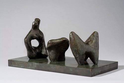 Small bronze model by Henry Moore of an abstract reclining figure, separated into three pieces.