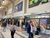 The main concourse of Leeds Train Station, with a Sainsbury's Local on the right side and benches.