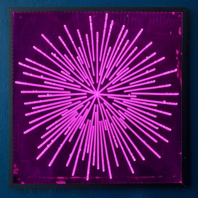 A square acrylic panel with a pink, starburst-like 'firework' pattern in the centre, which has been carved into the surface of the acrylic.