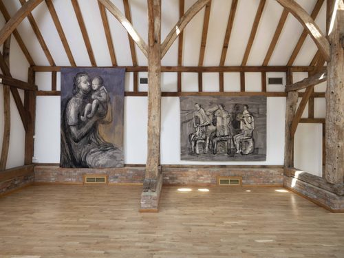 Two tapestries by Henry Moore hanging on the walls of a wooden beamed barn