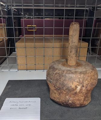 A wooden mallet used for carving sculpture, photographed in an archival setting.