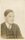 A faded archive photo, slightly sepia tinted, of a young boy (the artist Henry Moore) aged around 12. He is wearing a suit and tie.