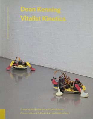 Cover of the book 'Dean Kenning : vitalist kinetics', showing two small, colourful, robot-like constructions on a gallery floor.