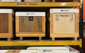 Wooden crates in a metal storage rack.