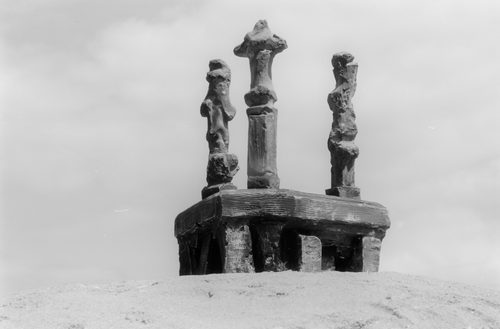 Three 'Upright Motive' plaster models by Henry Moore. They look like strange, slightly organic pillars. They have been photographed to make the sculptures appear larger than they actually are.