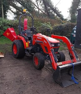 A small red electric loader (a type of tractor with a front-mounted bucket for scooping and moving earth or other loose material).