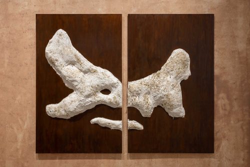 A white relief sculpture on board, in two parts.