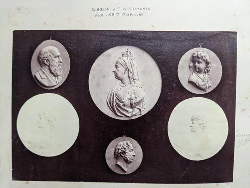 Black and white photo of a several round relief sculptures, depicting Queen Victoria and other people in silhouette.