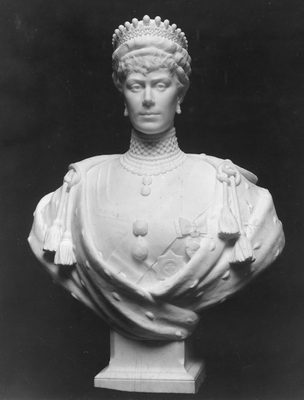 Black and white photo of a portrait bust of a royal figure, wearing a crown, earrings, a thick necklace made of pearls and military dress with medals.