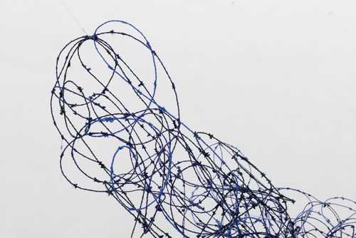 Close up photo of Lungiswa Gqunta’s sculpture 'Ntabamanzi' made from barbed wire and blue wool.