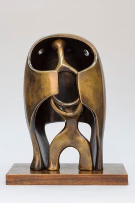 Abstract bronze sculpture fashioned in the style of a medieval helmet, with what could be a humanoid figure taking shelter inside.