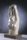 A colour photo of an abstract stone sculpture depicting the head and torso of a woman raising her arms above her head.