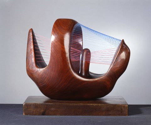 An abstract sculpture by Henry Moore, carved from wood to appear somewhat like a basket, with blue and red string threaded through it.