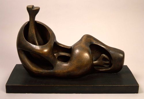 Abstract bronze sculpture by Henry Moore that gives the impression of a person reclining.