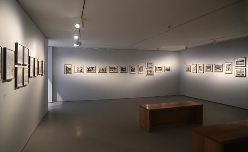 A gallery space with many framed black and white photos decorating the walls.
