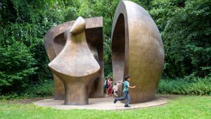 A group of children Children play hide and seek around Henry Moore's huge sculpture Large Figure in a Shelter.