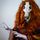 Profile photo of Rhubarbs, dressed in a costume comprising an animal skull, ginger wig, colourful poncho and white gloves.