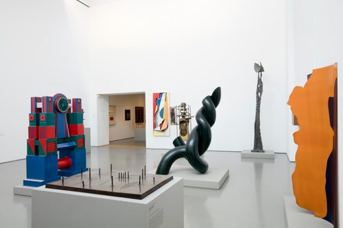 A large gallery space filled with sculptures.