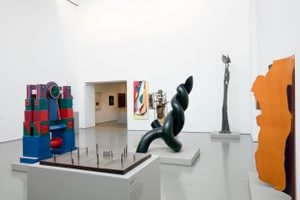 A large gallery space filled with sculptures.